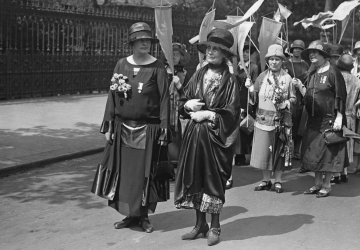 A photo of Lady Rhondda and Emmeline Pankhurst leading a demonstration. Behind them are women holding banners.