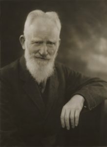 Black and white portrait of George Bernard Shaw wearing a dark coat